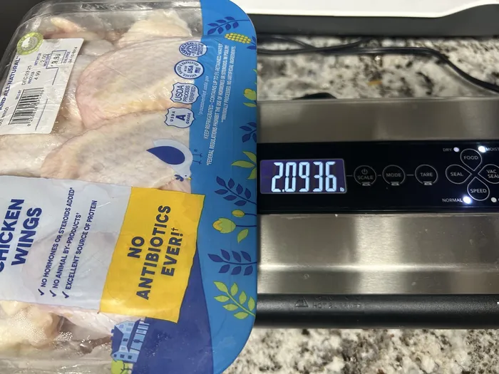 Kitchen scale showing the unopened package weighing 2.0936 pounds