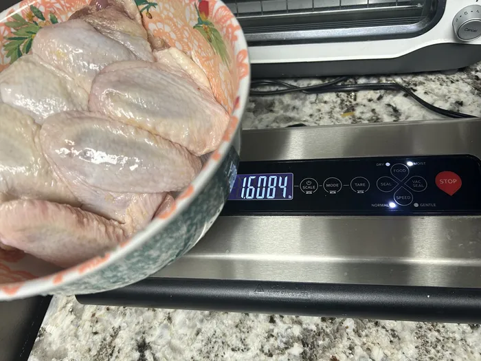 Kitchen scale showing the wings alone weighing 1.61 pounds after removing them from the tray