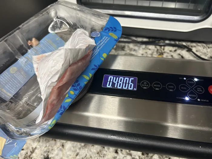 Kitchen scale showing the empty tray and absorbent pad weighing 0.48 pounds