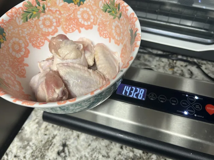 Kitchen scale showing the trimmed wings weighing 1.43 pounds after removing the wing tips