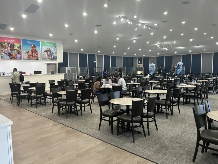 The Capital Vacations presentation room, with dining tables in front and sales cubicles along the back wall