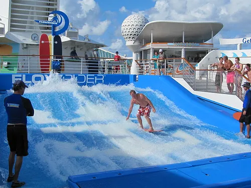 A stand-up surfer riding the FlowRider during a Mixed Wave session